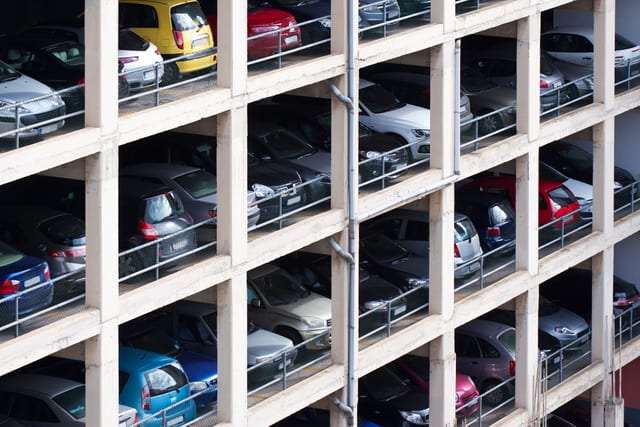 Cars parked on five stacked open decks of a multi-storey car park seen from outside